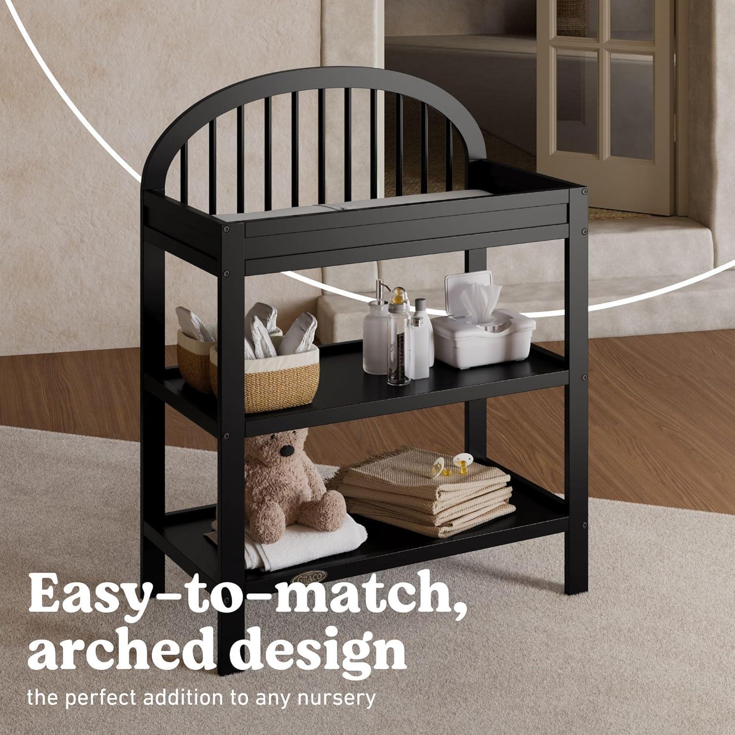 imageGraco Olivia Changing Table with WaterResistant Changing Pad Driftwood GREENGUARD Gold Certified Includes Bonus WaterResistant Changing Pad with Safety Strap 2 Open Shelves Stylish DesignBlack