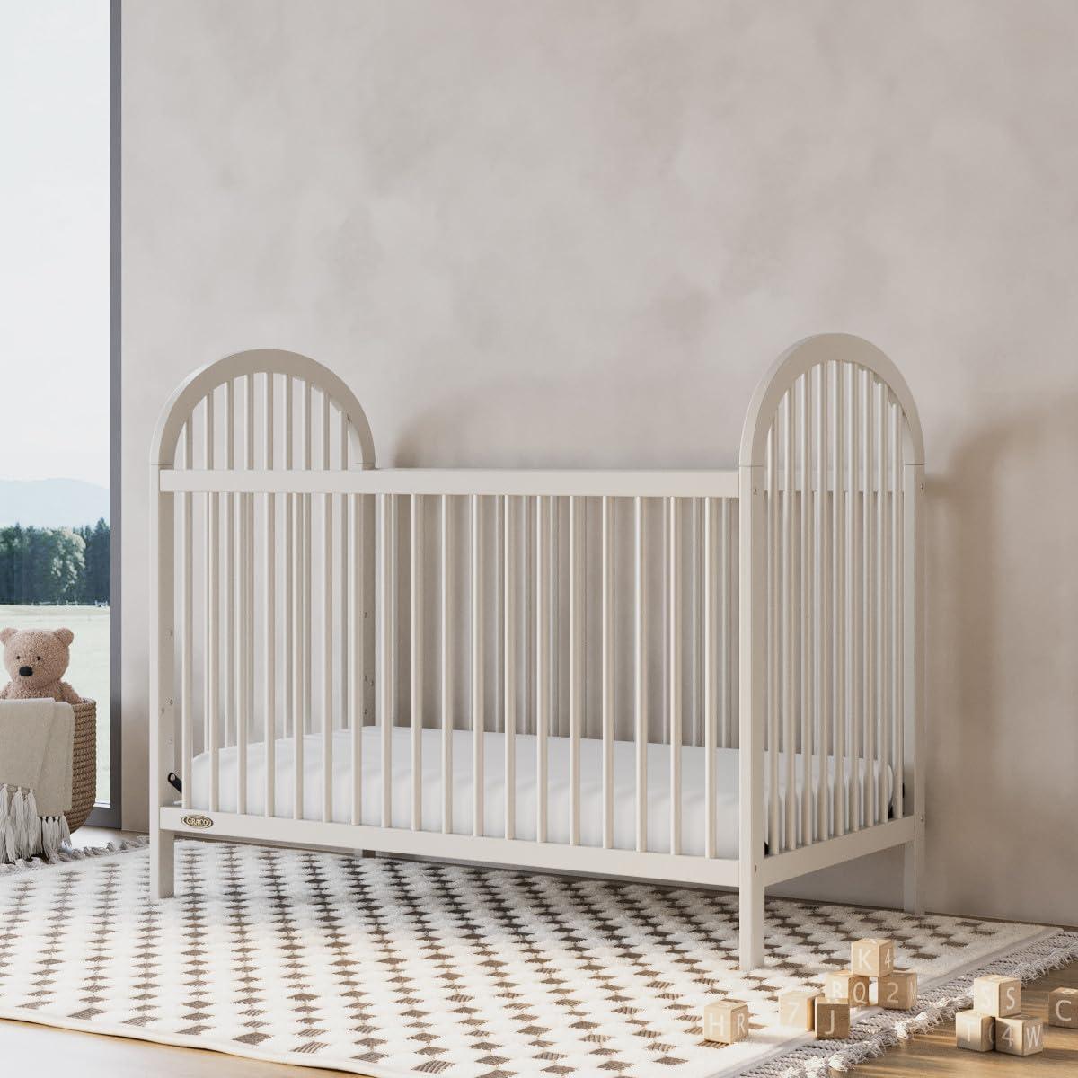 imageGraco Olivia Convertible Crib White GREENGUARD Gold Certified 100 Solid Wood Fits Standard Crib Mattress Converts to Toddler Bed and Daybed 4 Adjustable Mattress HeightsFrosted Oat